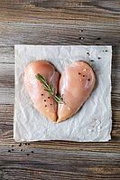 Raw chicken fillet in the shape of a heart with rosemary and spices on natural wooden background. Top view [IBR123639525]