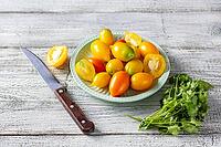 Various colorful ripe tomato on white wooden background. Cooking from yellow orange and red cherry tomatoes. Top view with copyspace [IBR123639566]