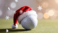 A golf ball wearing a red Santa hat sits on a green golf course. Snowflakes float around, creating a cheerful winter holiday atmosphere, copy space on the side. AI generated [IBR123641844]