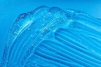 Transparent beauty cosmetic serum product. Hand sanitizer gel texture smear smudge swatch with bubble. Blue moisturizing cleanser, hair gel sample. Skincare makeup cream. Skin care clear liquid splash [IBR123646460]