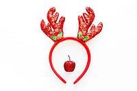 Festive Christmas reindeer made from red decor and headband with reindeer antlers with sequins. Minimal New year Santa creative concept. Flat lay [IBR123646465]