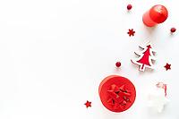 Christmas art composition with red decor, gift box and candle on white. Chritmas eve, noel, gift concept. Flat lay, top view, copy space [IBR123646466]
