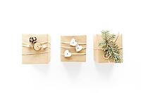 Christmas handmade gift boxes art composition on white surface. Gifts, christmas wooden decorations, fir branches, pine cone. Handmade DIY concept. Flat lay, top view, above [IBR123646492]
