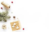 Christmas composition on white surface. Handmade present, holiday decorations, fir branches, pine cone. Christmas DIY concept. Flat lay, top view, copy space [IBR123646495]