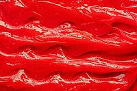 Red gel texture. Cosmetic clear liquid cream smudge. Skin care product sample closeup. Toothpaste or wax background [IBR123646504]