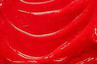 Red gel texture. Cosmetic clear liquid cream smudge. Skin care product sample closeup. Toothpaste or wax background [IBR123646506]