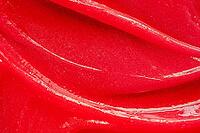 Red gel texture. Cosmetic clear liquid cream smudge. Skin care product sample closeup. Toothpaste or wax background [IBR123646508]