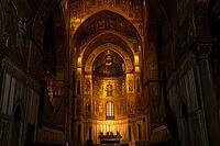 Monreale, Italy - 04.11.2022: Majestic church interior with illuminated altar and religious art in historic cathedral [IBR123646529]