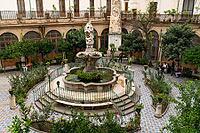 Palermo, Italy - 06.11.2022: Chiostro con fontana di San Domenico. Historic courtyard with ornate fountain and lush garden in a classical setting [IBR123646544]