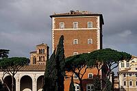 Rome, Italy - 09.12.2022: Ancient roman architecture Palazzo Venezia with tower and cypress trees under cloudy sky [IBR123646548]