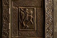 Monreale, Italy - 04.11.2022: Medieval knightly scene with intricate carved patterns on historical door [IBR123646555]