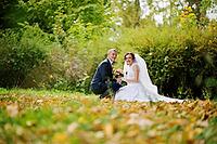 Wedding couple sitting at yellow leaves background autumn park [IBR123675078]