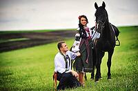 Young couple on national dress with horses [IBR123675134]