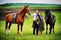 Young couple on national dress with horses [IBR123675137]