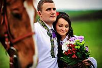 Young couple on national dress with horses [IBR123675138]