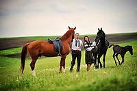 Young couple on national dress with horses [IBR123675140]