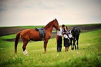 Young couple on national dress with horses [IBR123675143]