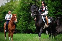 Young couple on national dress with horses [IBR123675146]