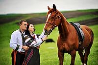 Young couple on national dress with horses [IBR123675158]
