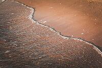 A wave walks along the sandy beach [IBR123700090]