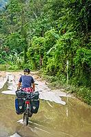 Female cyclist cycling on Trans-sumatran Highway in Sumatra, Indonesia [IBR123713396]