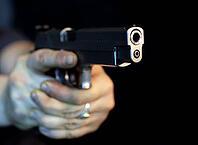 Man pointing a gun looking at the camera [IBR123723150]