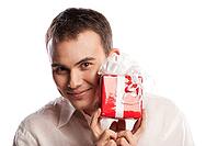 Close-up portrait of smiling man holding gift isolated on white background [IBR123723160]