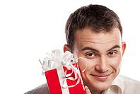 Close-up portrait of smiling man holding gift isolated on white background [IBR123723161]
