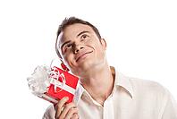 Close-up portrait of smiling man holding gift isolated on white background [IBR123723162]