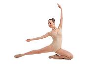 Young pretty ballet dancer sitting in elegant pose isolated on white [IBR123723197]