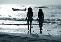 Two silhouettes of girls at coast of ocean [IBR123723215]