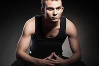 Closeup portrait of a sexy male model on dark grey background [IBR123723231]
