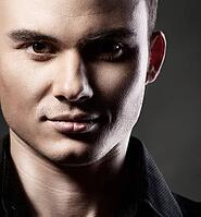 Closeup portrait of a sexy male model on dark grey background [IBR123723233]