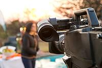 TV Camera and presenter host on a live news broadcast on location at sunrise [IBR123723347]