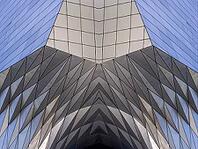 Abstract photography with a symmetrical, diamond-shaped shape that consists of repetitive lines and surfaces in shades of gray, white and blue and creates an impression of rhythm, depth and cool geometric harmony [IBR123760821]