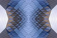 Abstract photography with a symmetrical, crystalline form, consisting of intertwined diamond-shaped surfaces in shades of blue, gray and subtle brown, which create a sense of depth, structure and cool architectural dynamism [IBR123760834]