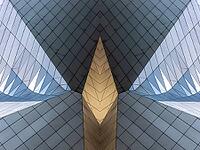 Abstract photography with symmetrical, sharp geometric forms of architecture in cool shades of gray and blue as well as warm beige, emphasizing the contrast of light, shadow and structure [IBR123760840]