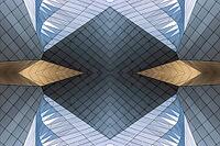 Abstract photography with symmetrical, sharp geometric forms of architecture in cool shades of gray and blue as well as warm beige, emphasizing the contrast of light, shadow and structure [IBR123760842]