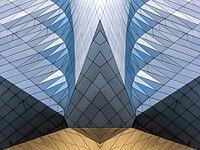 Abstract photography with symmetrical, sharp geometric forms of architecture in cool shades of gray and blue as well as warm beige, emphasizing the contrast of light, shadow and structure [IBR123760848]