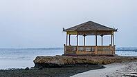 Lonely wooden pavilion on rocks on beach with cool, calm sea in the background, Shoni Bay, Egypt [IBR123769628]