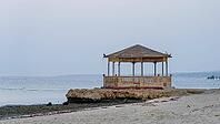 Wooden pavilion on a rock on a beach surrounded by the sea in peaceful twilight, Shoni Bay, Egypt [IBR123769629]