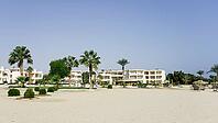Holiday complex with palm trees on the edge of a sandy beach under blue sky, Shoni Bay, Egypt [IBR123769638]