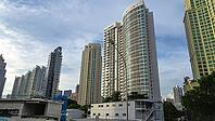 Modern skyscrapers rise into the sky of a city surrounded by trees and clear blue sky, Singapore, Singapore [IBR123769661]