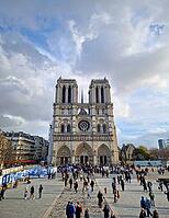 Paris, France - December 10, 2025: The Notre-Dame Cathedral visited by numerous tourists. The facade highlights intricate portals, the Gallery of Kings, the iconic rose window and massive bell towers [IBR123895596]