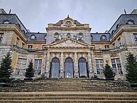 Maincy, France - December 11, 2025: Grand facade of Chateau de Vaux-le-Vicomte with cobblestone courtyard. Beautiful Baroque architecture decorated with small evergreen trees for the winter holidays [IBR123895602]