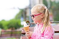 Little girl eating icecream [IBR123980444]