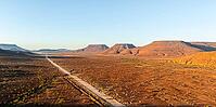 Aerial view, road leading through dry desert landscape, hills in Damaraland, Namibia [IBR123990967]
