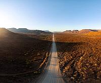 Aerial view, infinite space, straight road leads through dry desert landscape, hills in Damaraland, Namibia [IBR123990969]