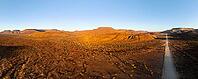 Aerial view, infinite space, straight road leads through dry desert landscape, hills in Damaraland, Namibia [IBR123990971]