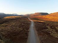 Aerial view, infinite space, straight road leads through dry desert landscape, hills in Damaraland, Namibia [IBR123990977]